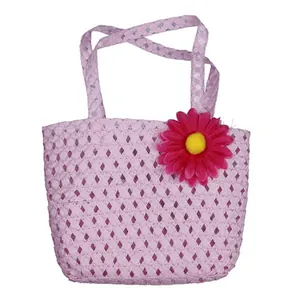 Detailed view of children's pink woven handbag with a large pink daisy flower decoration
