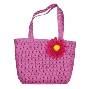 Detail of kids pink woven straw handbag with a decorative yellow sunflower accent