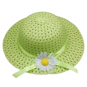 Detail of green straw sun hat with woven texture, green ribbon, and white daisy flower