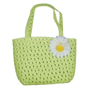 Detail of light green straw woven handbag with a white daisy flower decoration