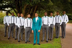 Wedding set featuring peacock green bow tie and black suspenders for groomsmen in nature