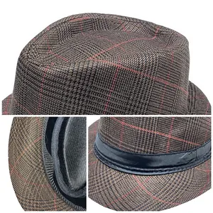 Detail view of brown plaid fedora hat showing textured fabric and black satin ribbon band