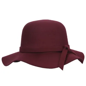 Détail d'un chapeau en feutre bordeaux à bord large avec ruban décoratif assorti