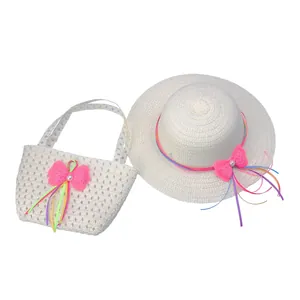 Close-up of kids straw hat and matching bag with pink bows and rainbow ribbons