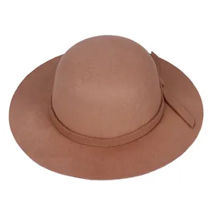 Gros plan d'un chapeau en feutre de laine marron montrant la texture et le ruban assorti
