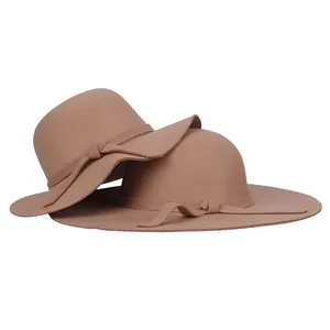 Détail d'un chapeau en feutre camel avec ruban en tissu assorti et nœud décoratif simple