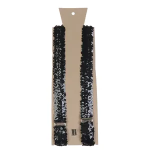 Detailed view of black sequined suspenders with silver metal clips on kraft cardstock