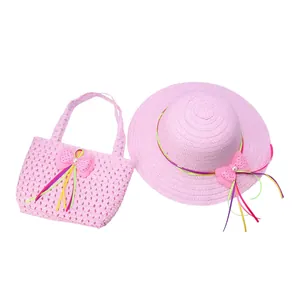 Detailed view of pink straw sun hat and matching handbag set with pearl bow for children