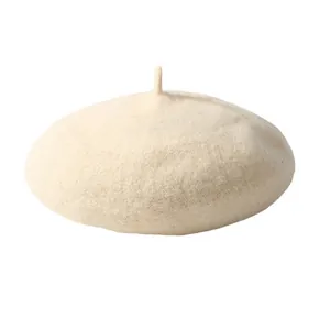 Gros plan d'un béret en laine beige avec texture épaisse et détail de tige classique