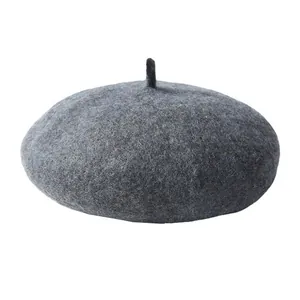 Gros plan d'un béret en laine gris foncé montrant la texture et le détail du haut
