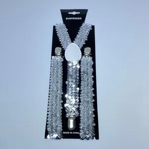 Detail of silver sequin suspenders with metallic clips on a professional display card