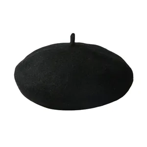 Gros plan sur la texture du béret en laine noire et le détail de la tige