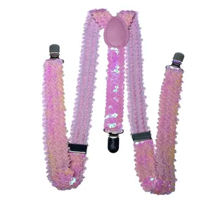 Close-up of pink sequin suspenders featuring silver metal clips and lilac leather joins