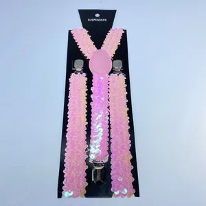 Macro view of pink sequin Y-back suspenders with silver metal clips on card