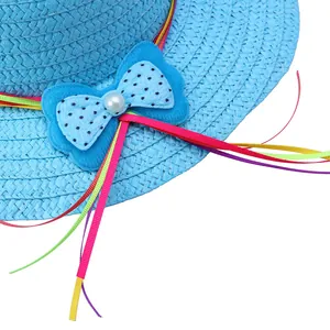 Detailed close-up of sky blue straw hat with polka dot bow and pearl for kids