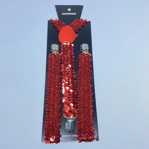 Detail of red sequined suspenders with silver metal clips on black card packaging