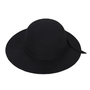 Vue détaillée de la texture du feutre lisse et du bord plat de ce chapeau noir élégant