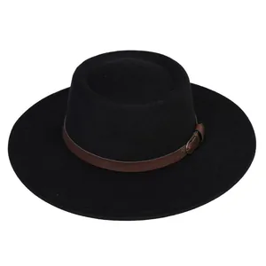 Detail of black wool felt boater hat featuring a brown leather strap and gold buckle