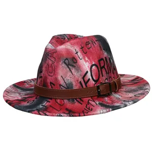 Detail of red and black tie-dye fedora hat with graffiti text and brown leather belt