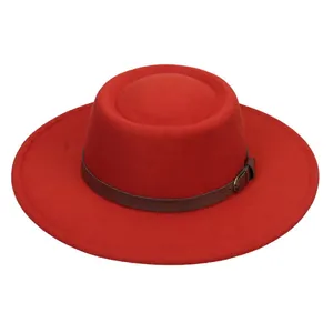 Detail of red wool felt boater hat with brown leather band and brass buckle accent