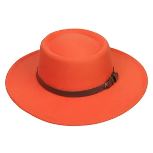 Detail of orange wool felt boater hat with wide brim and brown leather buckle band