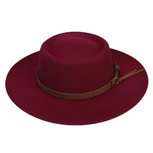 Close-up of burgundy wide brim wool fedora with brown leather strap and metal buckle