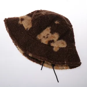 Détail du chapeau bob en laine d'agneau pelucheuse avec motif de lettres et cordon interne