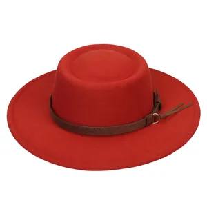 Detail of red flat-top felt hat featuring a dark brown leather band and metal ring