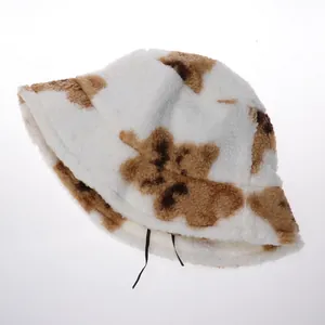 Détail d'un chapeau bob en laine d'agneau blanche avec motifs marrons et cordon de serrage interne