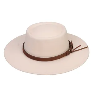 Detail view of beige flat top fedora with brown leather band and tassel accents