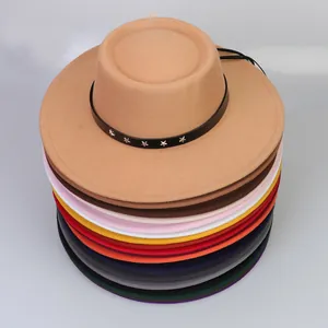 Detalle de sombreros de fieltro apilados con correas de cuero y adornos de estrellas de plata