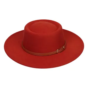 Detail of red wool felt fedora with brown leather strap and golden metal buckle