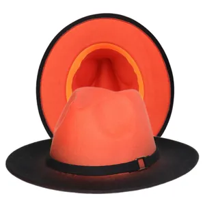 Detail view of orange felt fedora hat with black trim and metal buckle detail