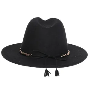 Detail of black wool fedora featuring gold chain band and decorative dual tassels