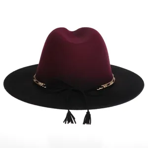 Close-up of two-tone burgundy wool fedora with gold chain and tassel detail