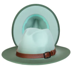 Détail d'un chapeau Fedora bicolore montrant le feutre vert et la boucle de ceinture brune