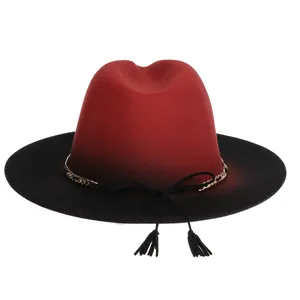 Detail of red and black gradient wool fedora hat with gold chain and dual tassels