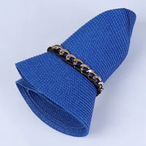 Nahaufnahme eines hellblauen Strohhuts mit goldener Kette und schwarzem Zierband für Damen