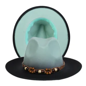 Detail of black fedora with mint green underside and beaded brown leather band