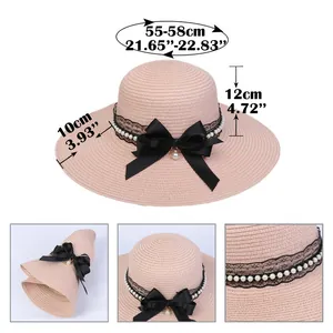 Pink straw sun hat for women with black bow, pearls and lace decoration on white background
