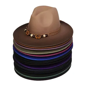 Stack of colorful felt fedora hats with ethnic beaded bands on white background