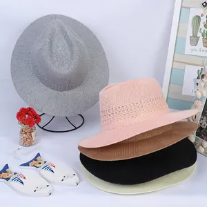 Various colorful woven panama hats displayed with summer accessories on white background