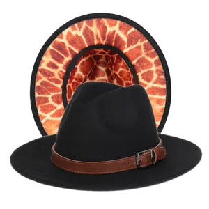 Détail du chapeau fedora noir avec boucle de ceinture et revers imprimé girafe orange