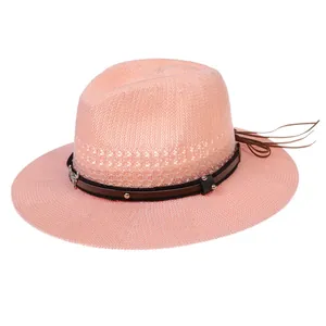 Detail of pink woven straw hat featuring brown leather band with bull pendant