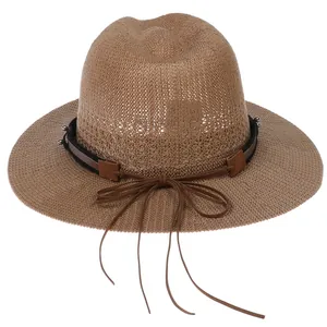 Detailed close-up of woven straw hat texture with decorative leather band and bow detail