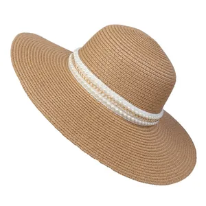 Detailed view of women's straw sun hat with elegant pearl and gold chain ribbon trim