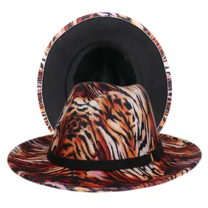 Detail of tie-dye leopard print fedora hat featuring a black belt with gold buckle