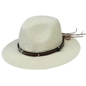 Macro shot of fedora hat with silver bull head emblem and leather fringe detail