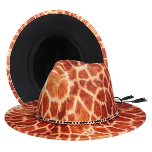 Detail of giraffe print fedora hat with gold metal chain and black tassel accents