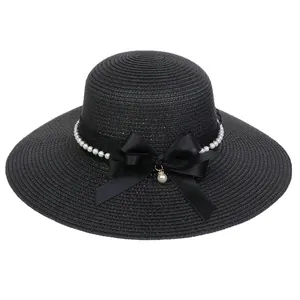 Elegant black wide brim straw hat with pearl band and large bow for beach vacations